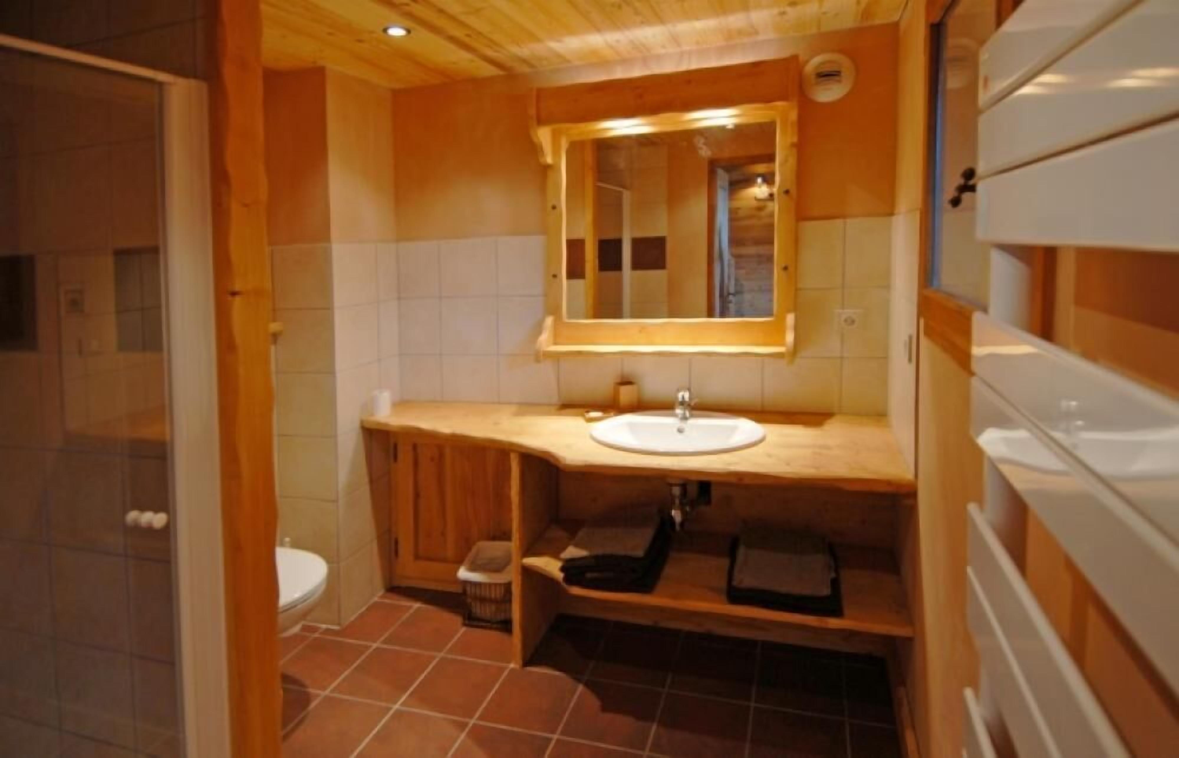 Une petite salle de bain avec un meuble-lavabo en bois, un évier et un miroir.