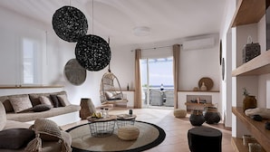 A modern living room with a sofa, coffee table, and hanging light fixtures. - Villa Delmar - Delmar Collection (Milos)