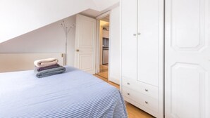 Quarto com uma cama grande, um guarda-roupa e uma porta para um banheiro.
