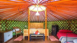 A yurt with a wooden bed, a bench, and a small table. - Società Agricola Cacigolara (Borgo Val di Taro)