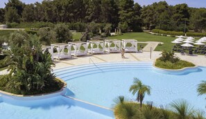 A pool with white lounge chairs and a gazebo, surrounded by greenery and trees. - Vivosa Apulia Resort - All Inclusive (Ugento)