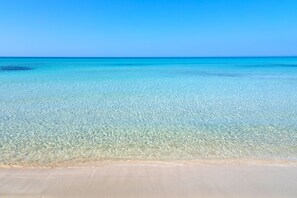 A clear view of a beach with a sandy shore and calm turquoise waters. - Vivosa Apulia Resort - All Inclusive (Ugento)