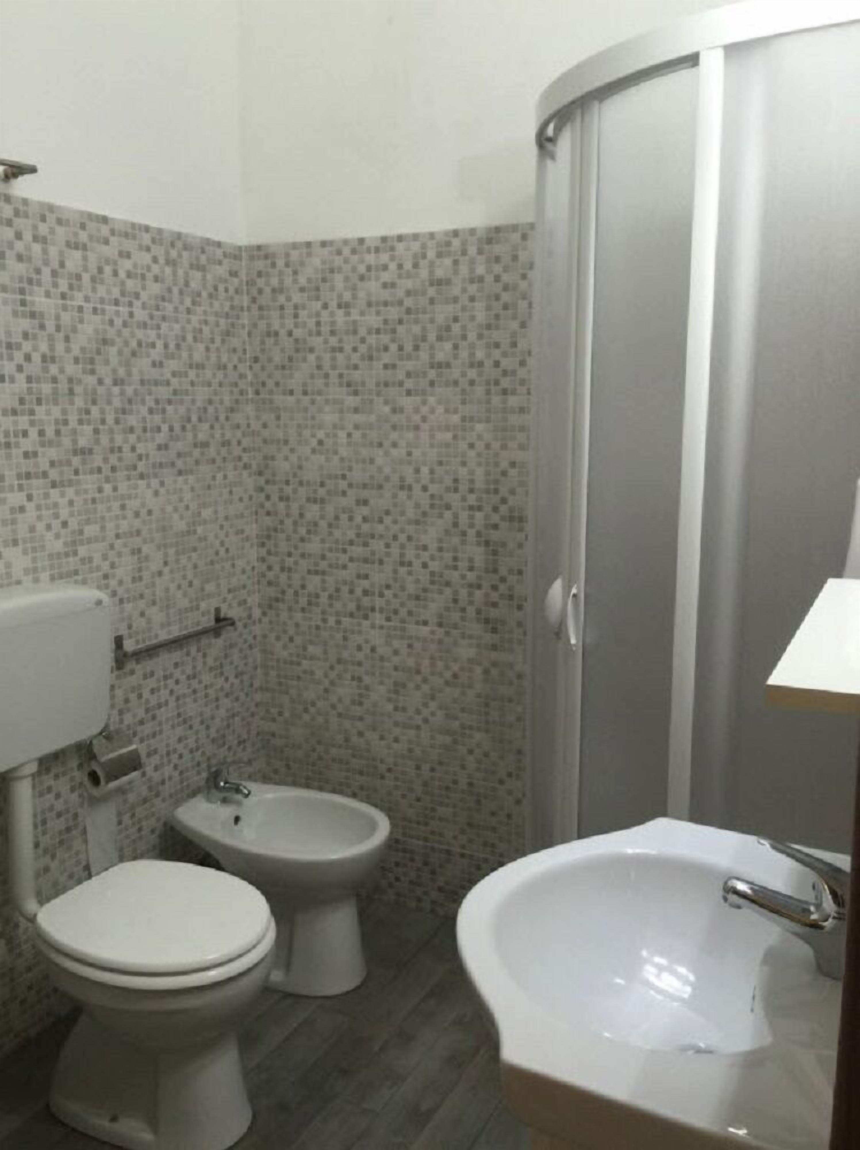 A bathroom with a toilet, bidet, and sink.