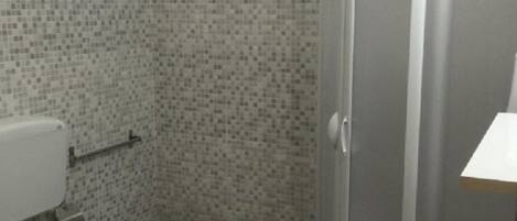 A bathroom with a toilet, bidet, and sink.