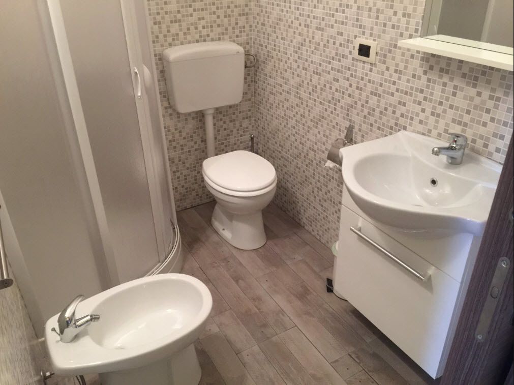 A bathroom with a toilet, bidet, and sink.