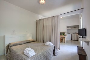 A hotel room with a bed, a desk, a television, and a kitchenette. - Tenuta Sant'Andrea (Muro Leccese)