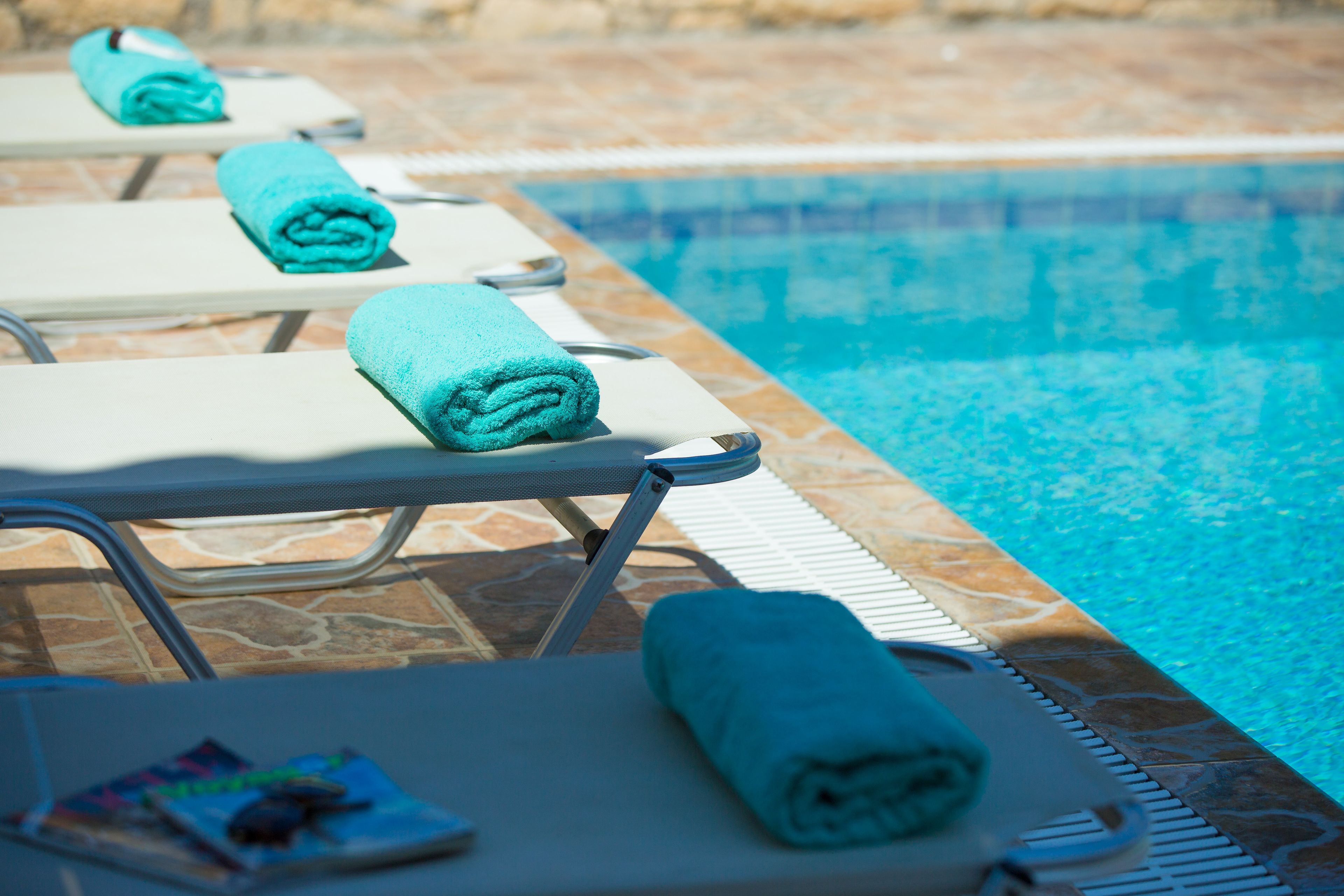 A poolside area with lounge chairs and towels.
