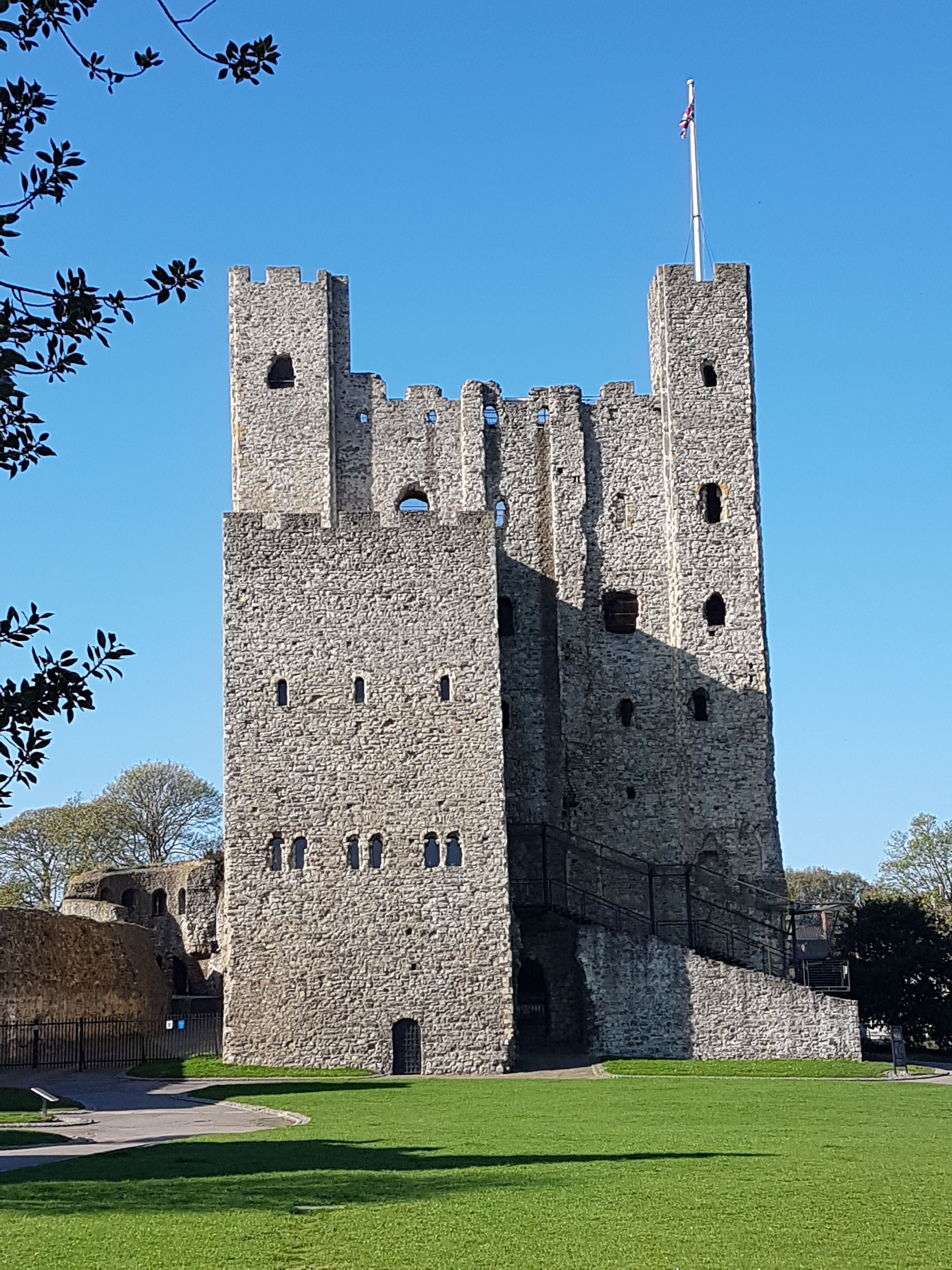 Un castillo de piedra histórico con múltiples torres y un asta de bandera.