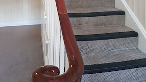 A staircase with a wooden handrail and carpeted steps. - Apartment 9 Robertson Villas (Rochester)