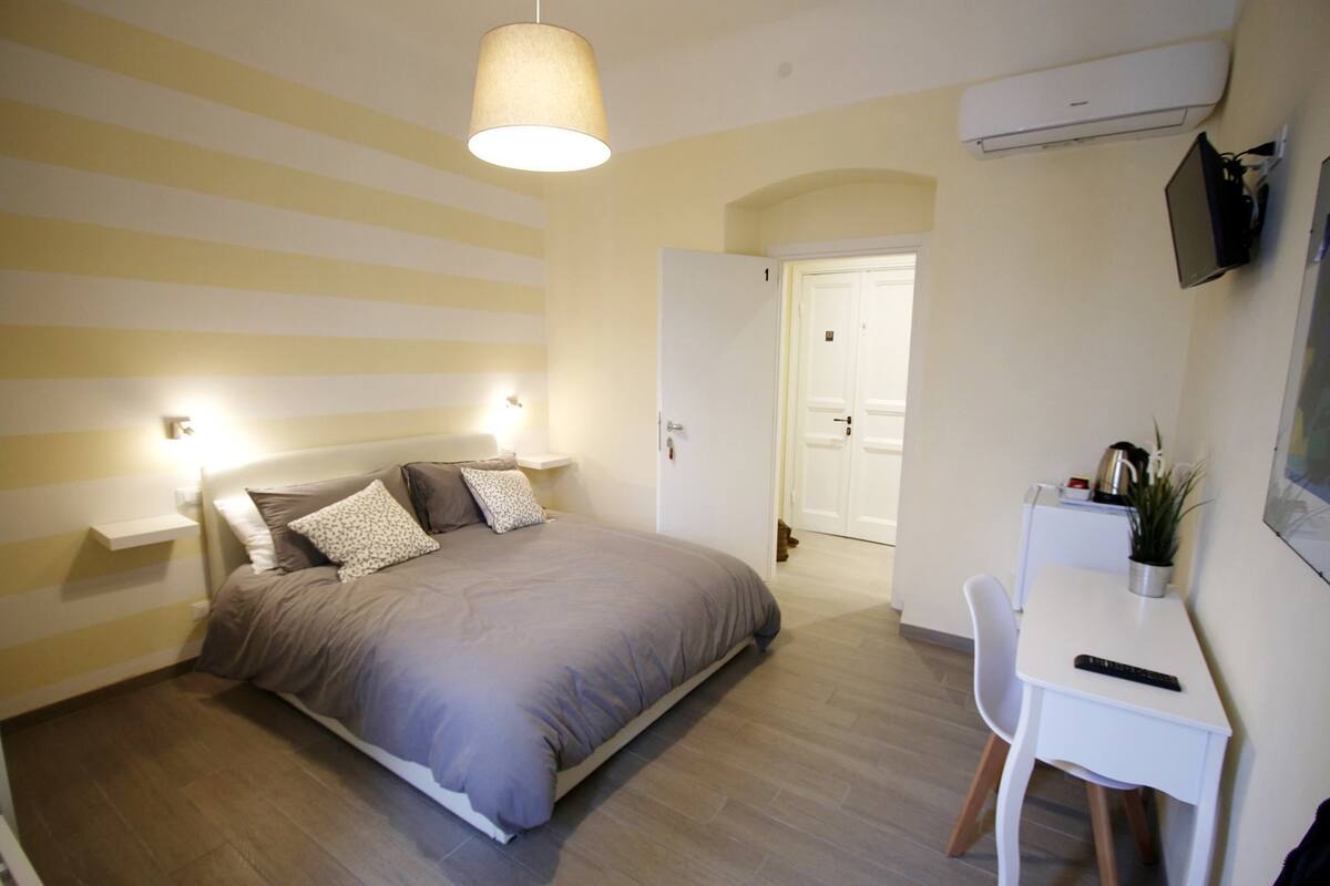 Ein Schlafzimmer mit Bett, Nachttischen, einem Schreibtisch und einem Stuhl.