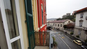 Une vue de rue avec des bâtiments, une route agrémentée de flèches directionnelles et une voiture jaune garée sur le bord.