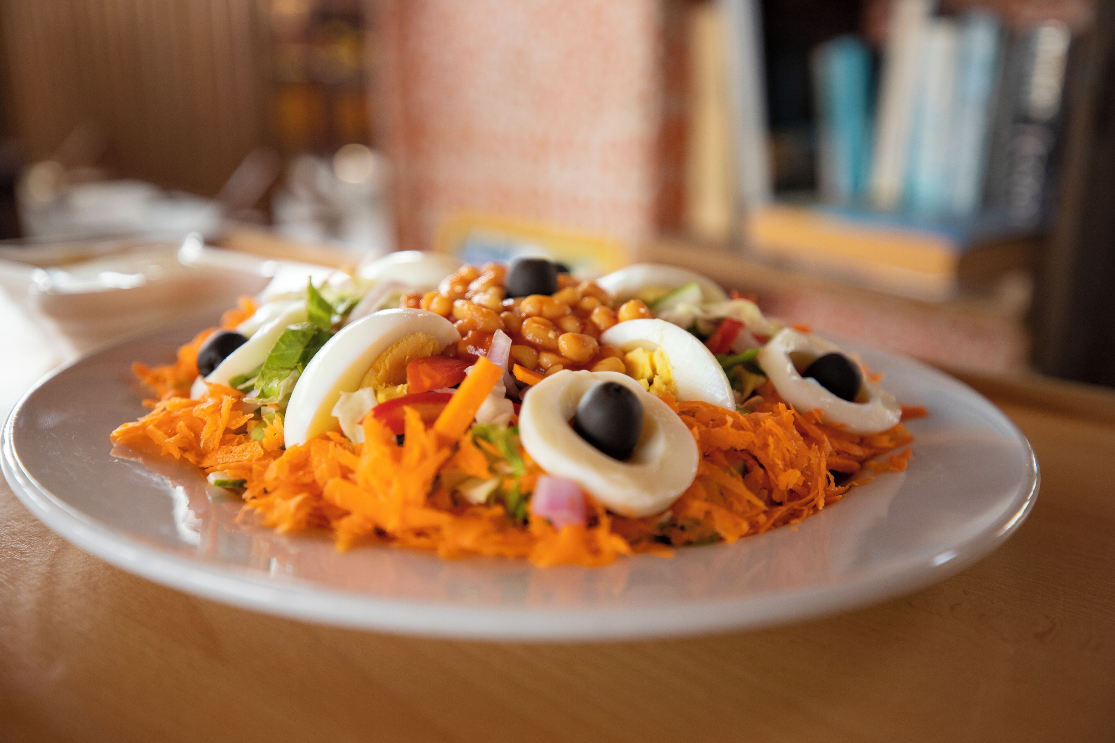 A plate of food with carrots, eggs, and beans.