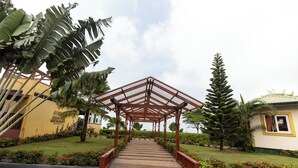 A covered walkway leading to a building with a yellow facade and a sign for 'AK Ocean Front Restaurant'.