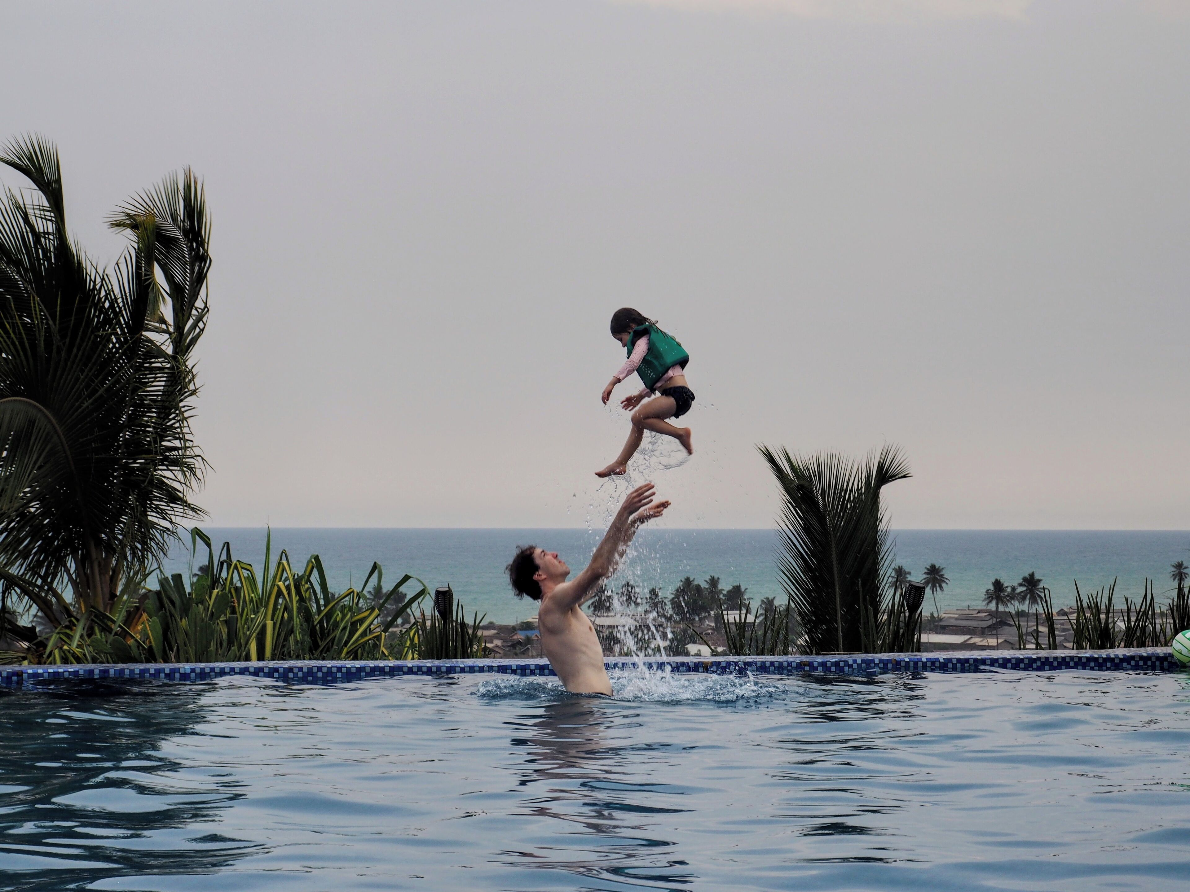 Una piscina con vista al océano y palmeras.