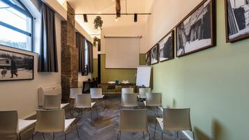 Ein Konferenzraum mit einem langen Tisch, Stühlen, einer Tafel und gerahmten Bildern an den Wänden.