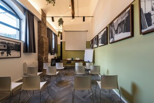 A conference room with a long table, chairs, a whiteboard, and framed pictures on the walls.