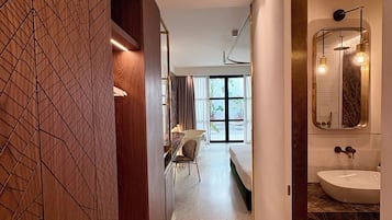 Un baño moderno con un espejo grande, un lavabo y una zona de ducha.