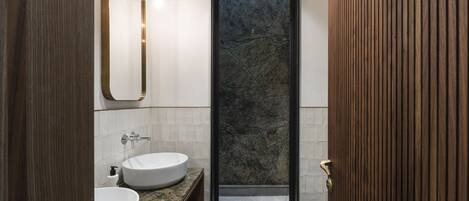 A modern bathroom with two sinks, a large mirror, and a shower area.