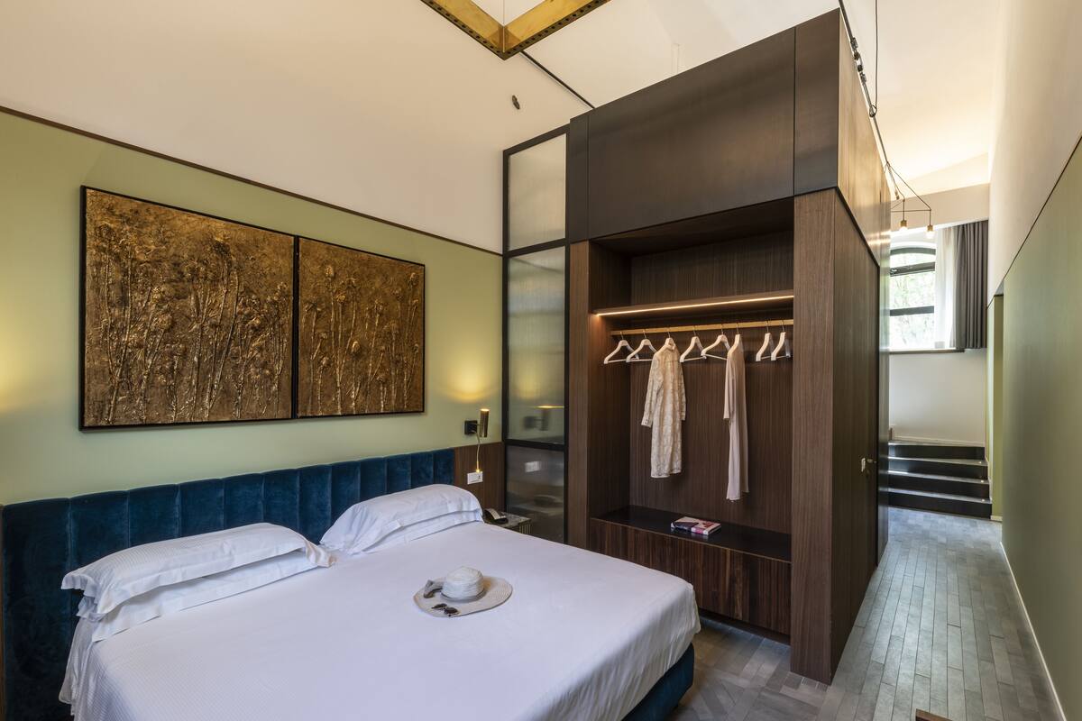 Habitació d'hotel moderna amb un llit gran, un armari encastat i vista a l'exterior.