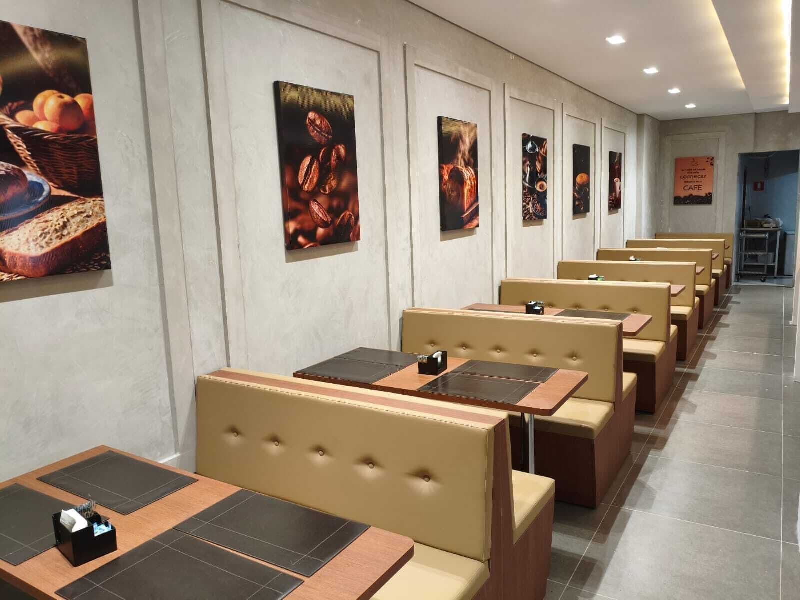 A restaurant interior with booth seating, tiled flooring, and wall-mounted artwork.