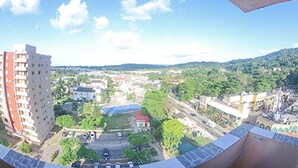 A panoramic view of a cityscape with a prominent high-rise building, a mix of residential and commercial buildings, and a clear sky. - Sword Fish Beach Suite at Turtle Towers (Ocho Rios)