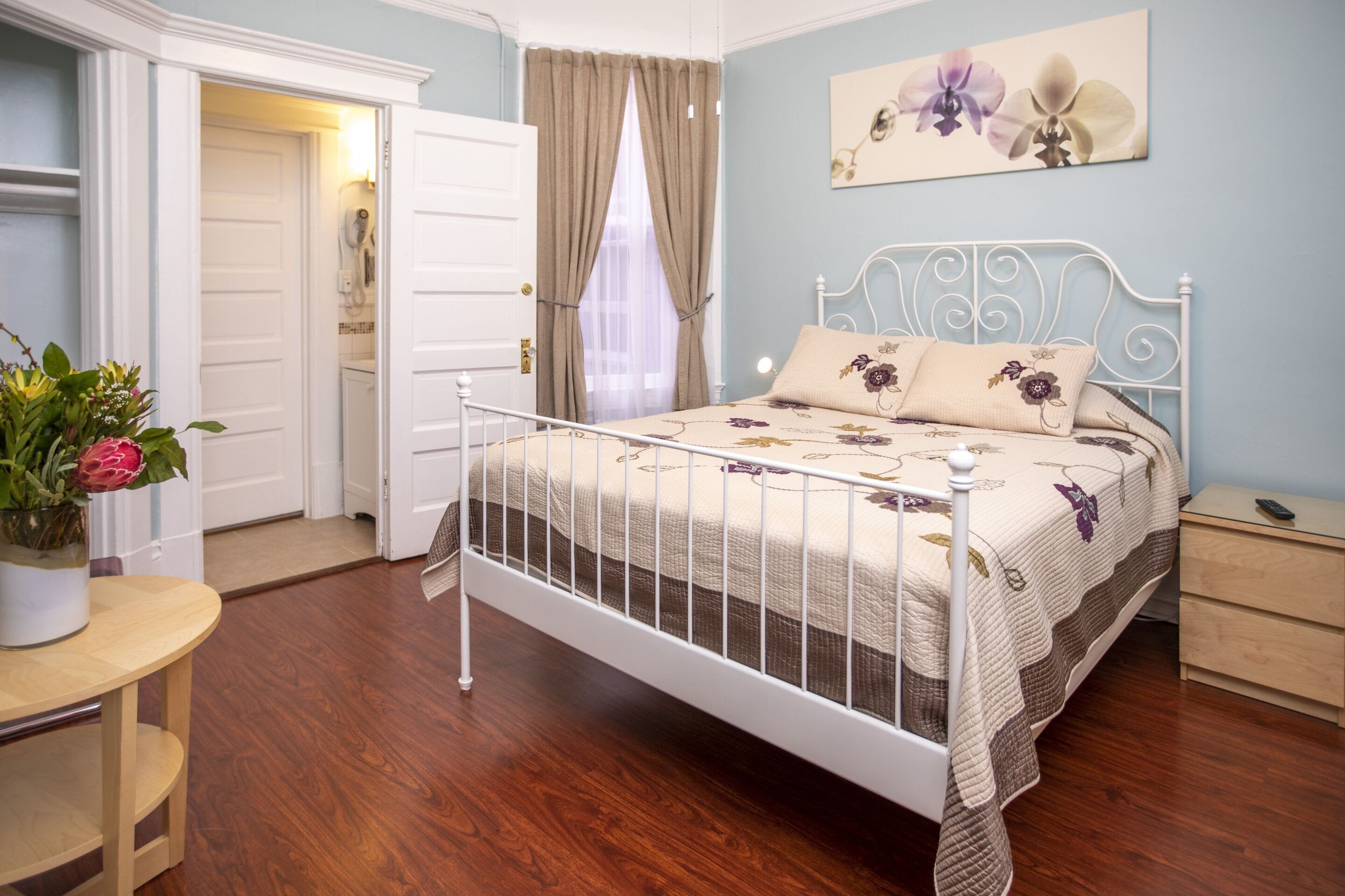 A bedroom with a bed, bedside table, and a nightstand.