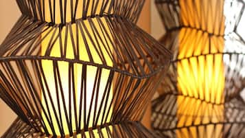 A series of geometric, black metal wall sconces with warm lighting.