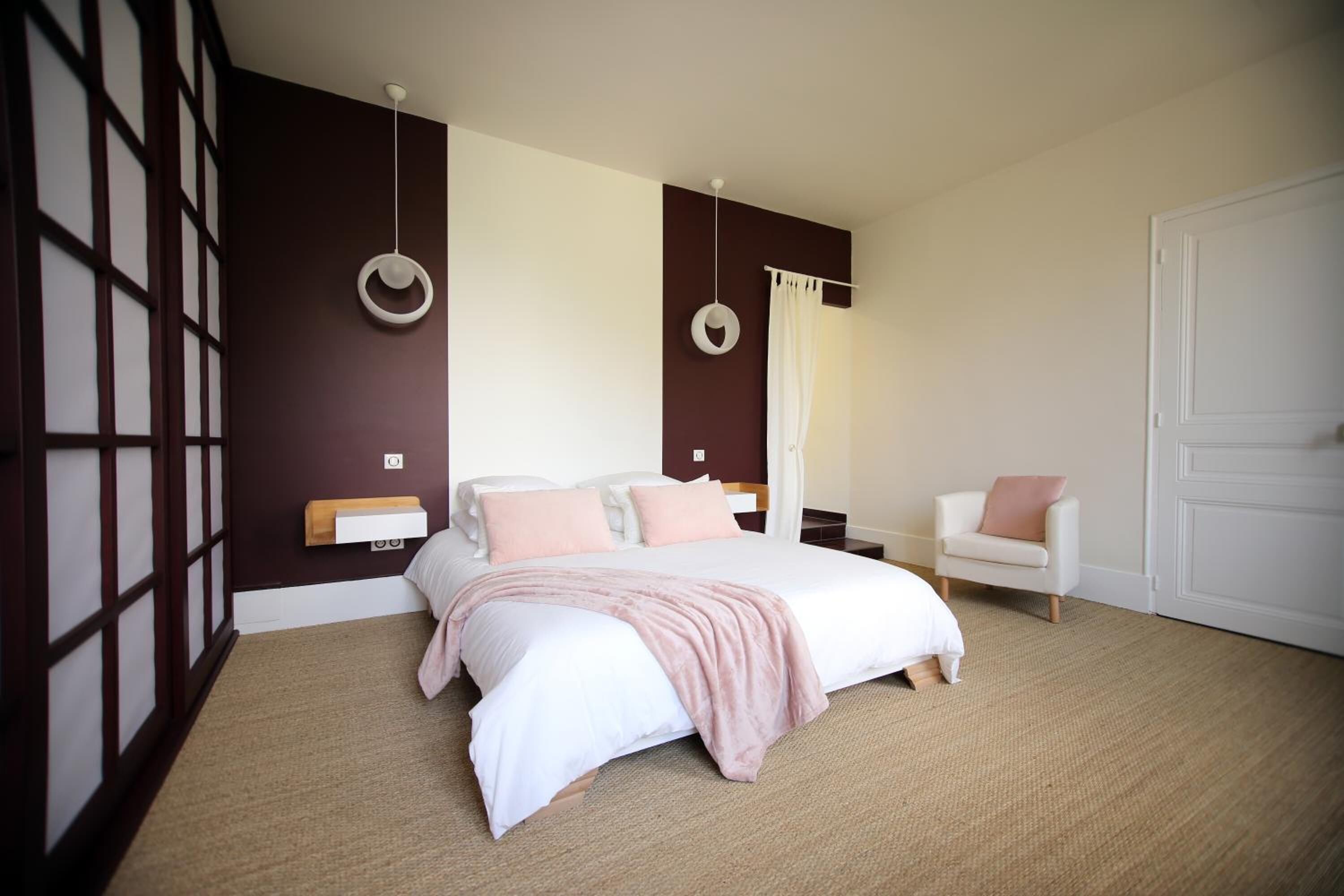 Un dormitorio con una cama grande, una mesita de noche, una silla y un armario.