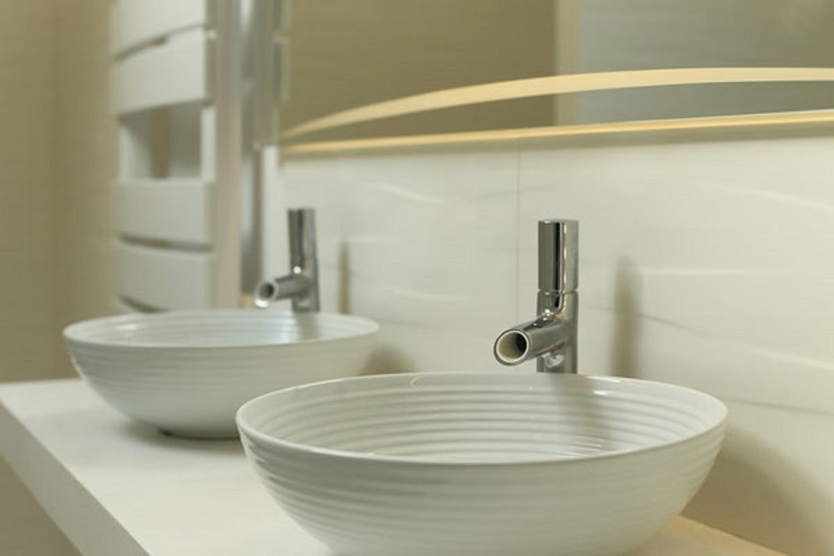 Ein Badezimmer mit zwei weißen Keramikwaschbecken und einer modernen Armatur.