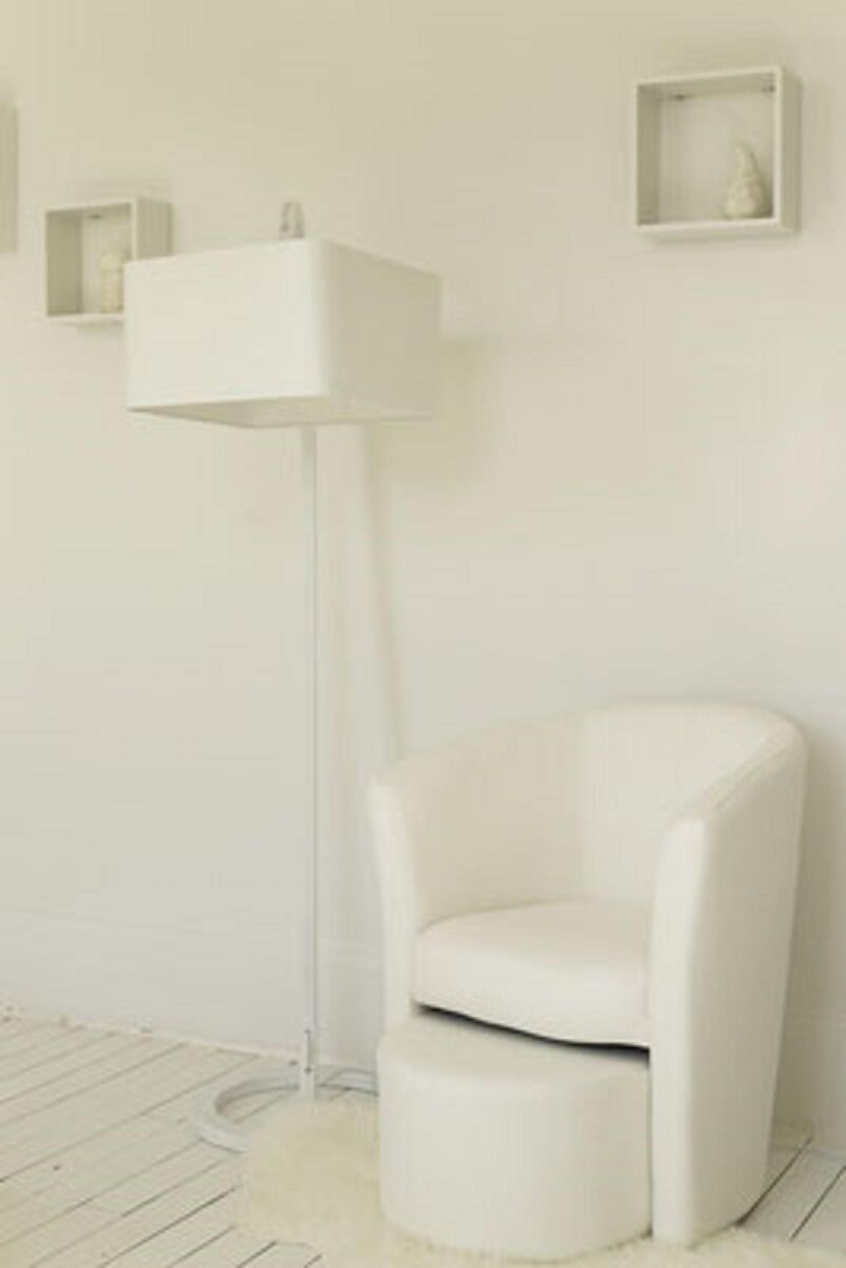 Een moderne, minimalistische kamer met een witte stoel, een vloerlamp en een klein plankje met een decoratief object.