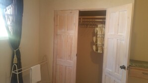Una puerta de madera con una toalla blanca colgada en un perchero a la izquierda.