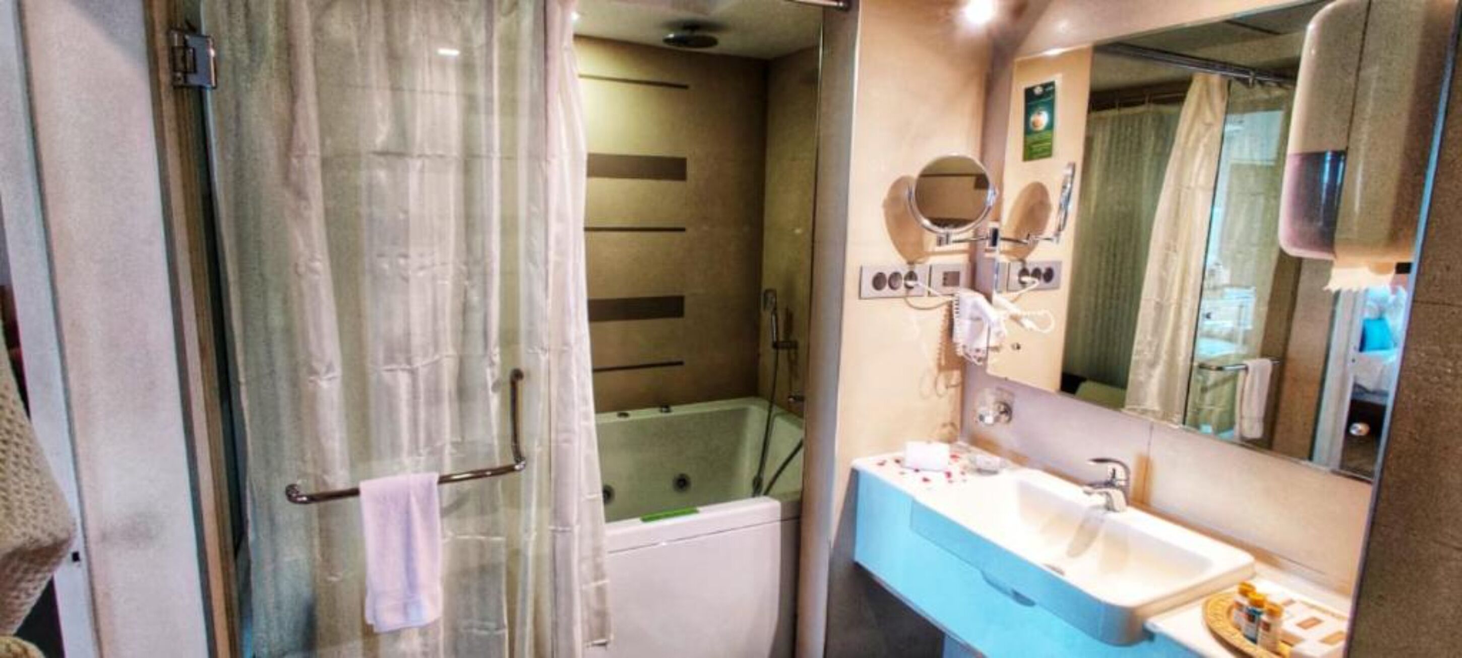 Een badkamer met een douche, een bad en een wastafel met spiegel.