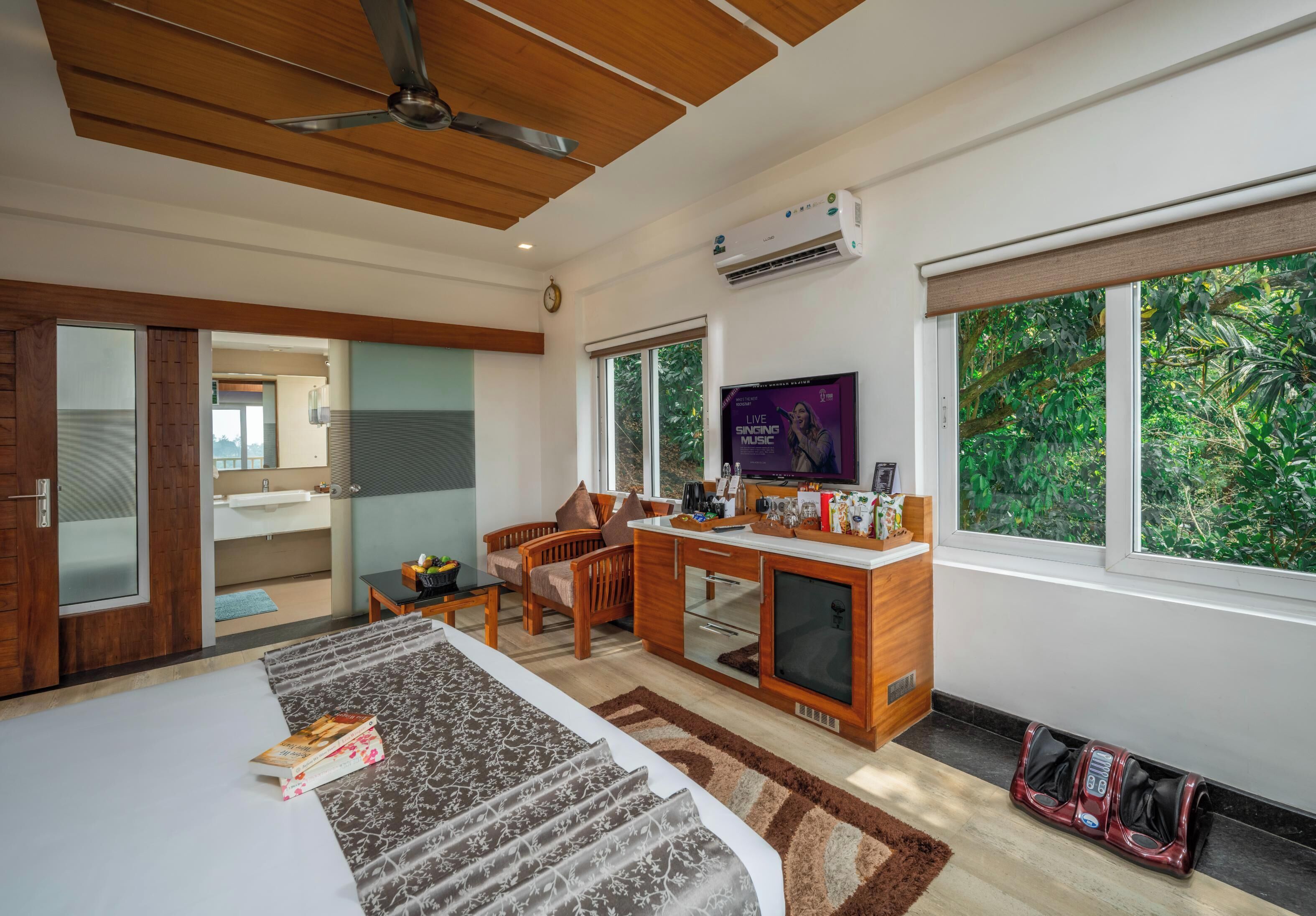 Una habitación de hotel moderna con cama, escritorio y ventanas amplias.