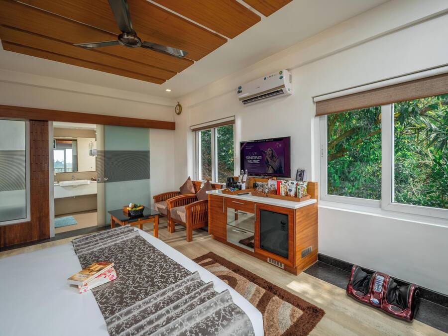 Una habitación de hotel moderna con cama, escritorio y ventanas amplias.