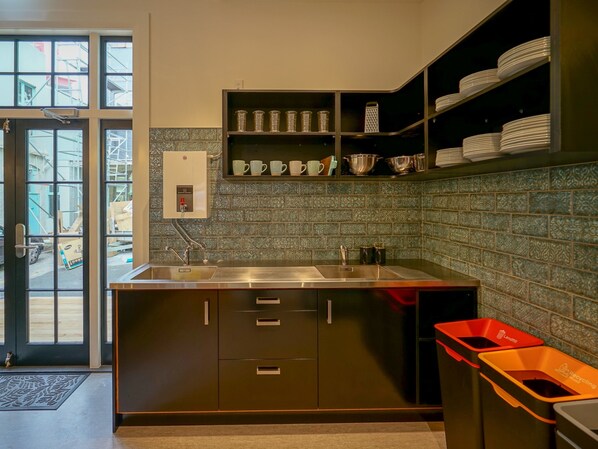 A modern kitchen with a built-in sink, stainless steel cabinets, and a decorative backsplash.