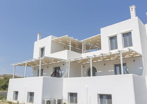 A modern white building with multiple balconies and large windows. - Salinus Villas (Naxos)