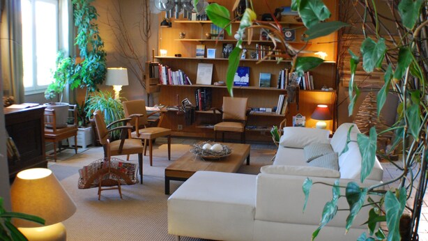 A cozy living room with a sofa, chairs, a coffee table, a bookshelf, and a lamp. - Résidence l'Atelier (Ennezat)