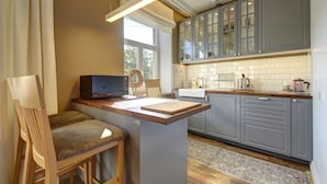 A modern kitchen with grey cabinets, a wooden island, and a built-in microwave.