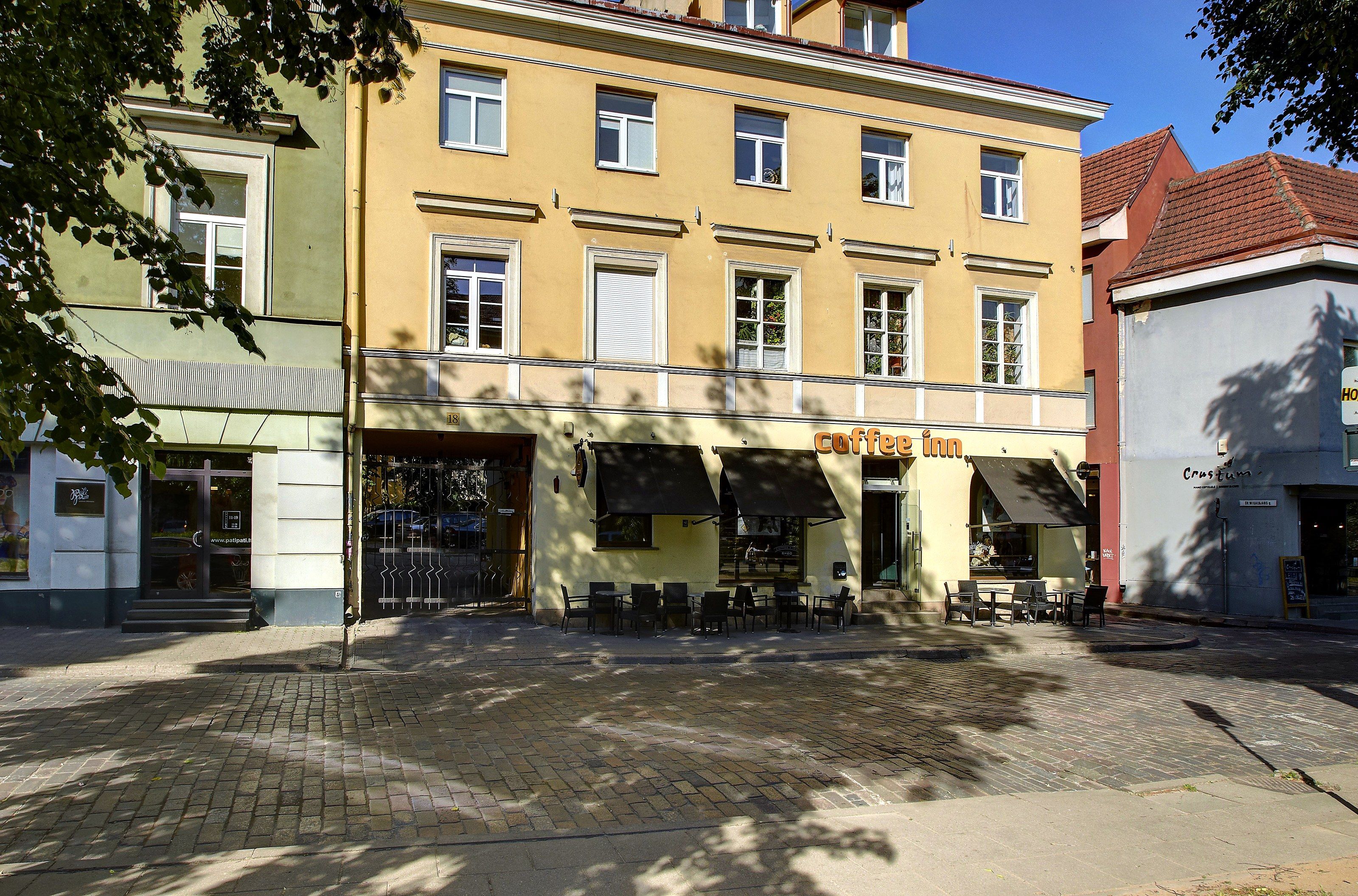 A building with a ground-floor coffee shop named 'Coffee Inn' and an upper-floor restaurant named 'Crostum.'