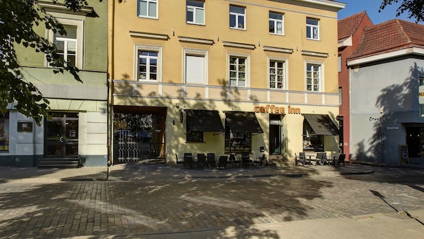 A yellow building with a coffee shop on the ground floor.
