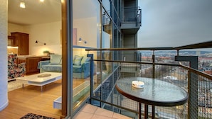 A modern apartment with a balcony, a kitchen area, and a living room with a sofa and coffee table. - Helios City Vilnius Apartments (Vilnius)