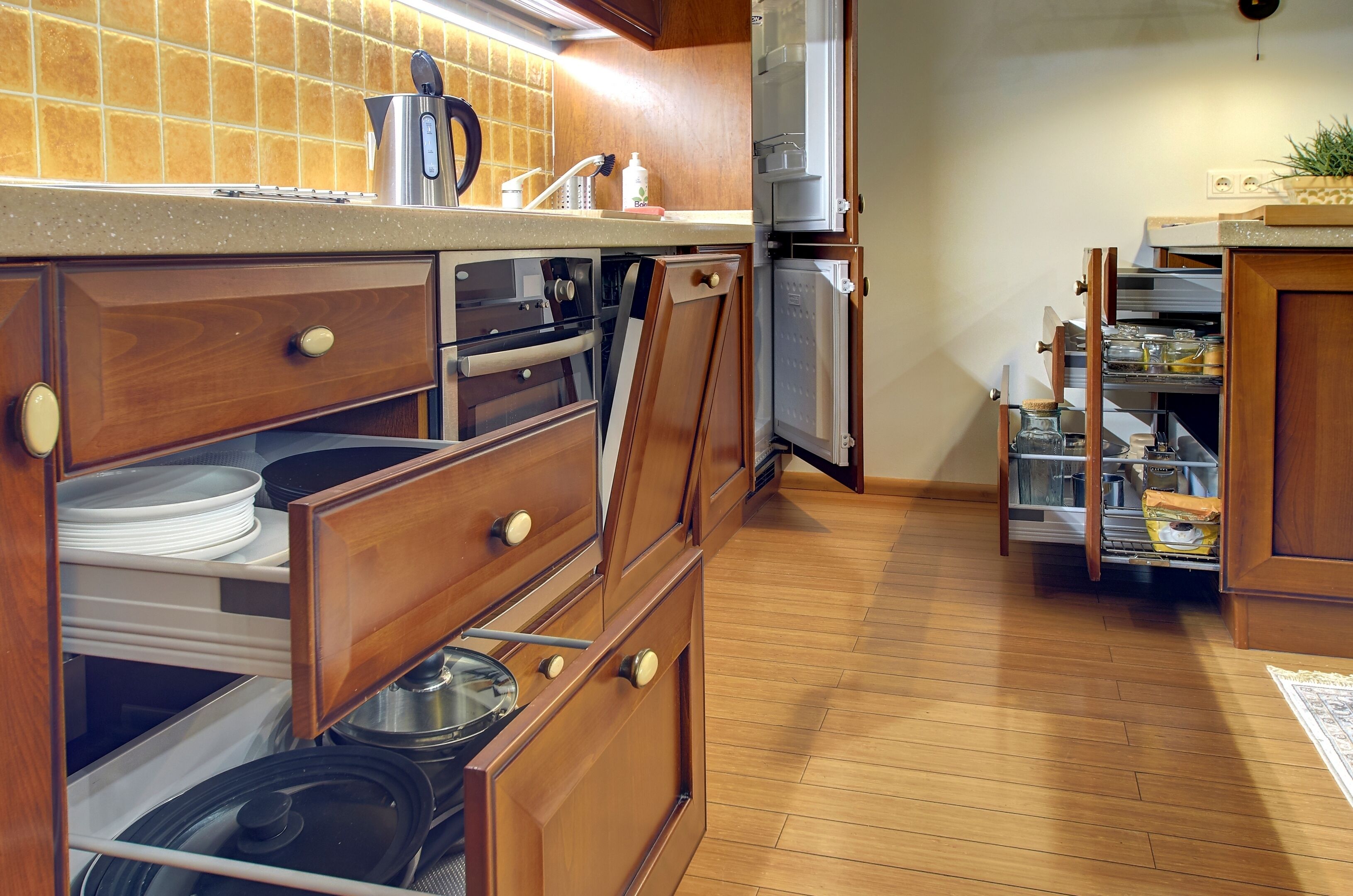 A kitchen with wooden cabinets, a stainless steel refrigerator, and a countertop with a coffee maker.