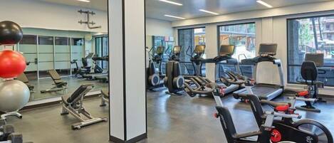 A gym with treadmills, stationary bikes, and weight machines.
