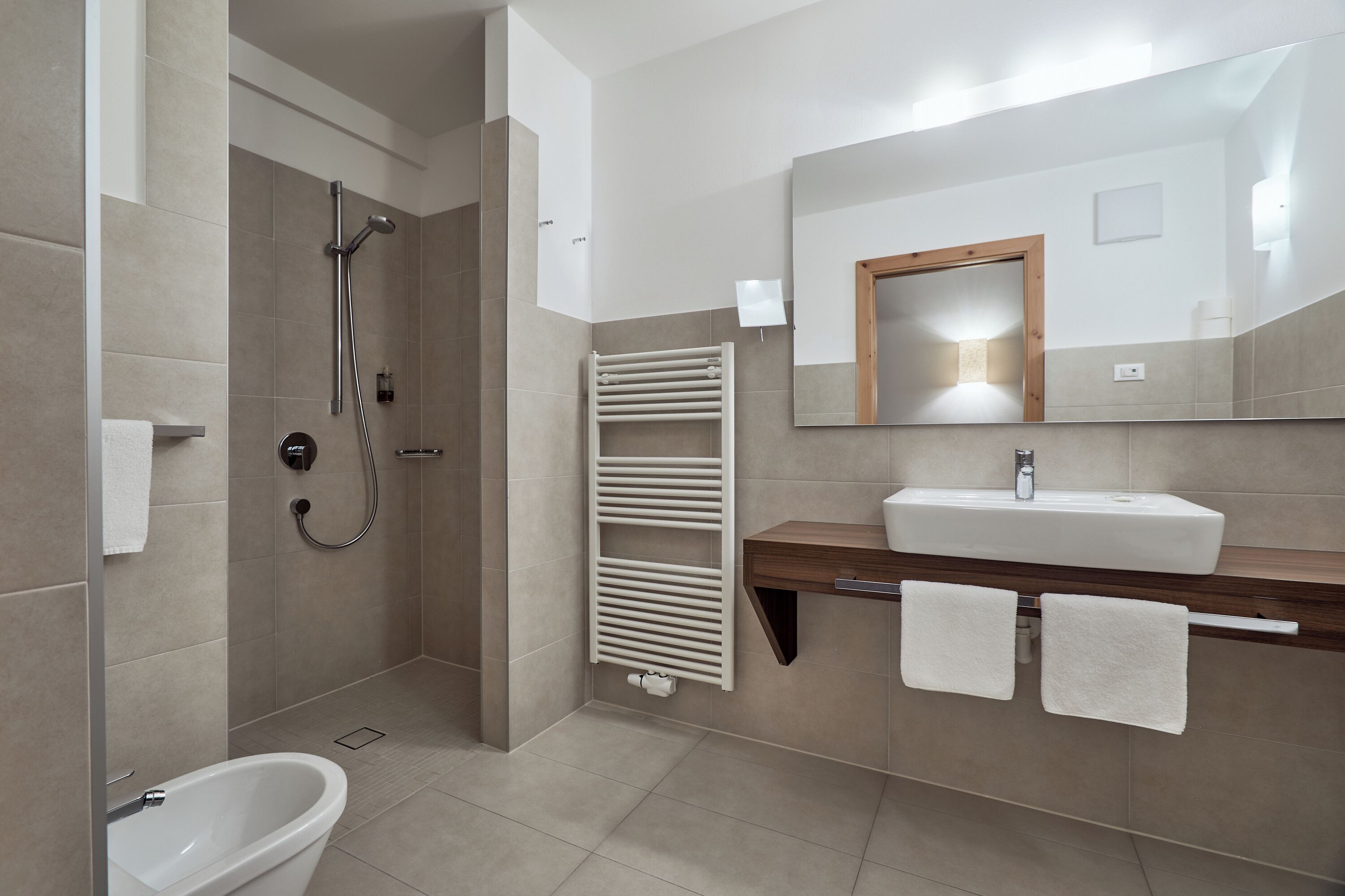 A modern bathroom with a shower, toilet, and sink.