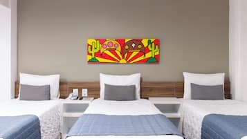 A hotel room with two beds, a bedside table with a phone, and a colorful abstract painting on the wall.