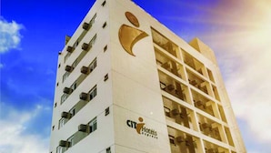 A high-rise hotel building with multiple balconies and a prominent logo on the facade.
