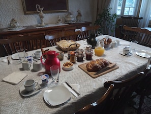 A breakfast table set with various items including bread, pastries, and beverages. - Maison Lalongère (Longueville)