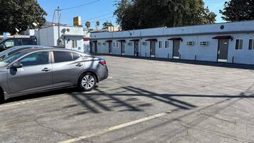 Un estacionamiento con un coche plateado estacionado al frente.