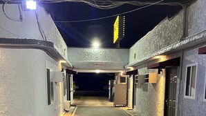 A narrow, well-lit corridor with a sign indicating an office, leading to a building entrance. - Griffith Park Motel - LA Hollywood Area (Glendale)