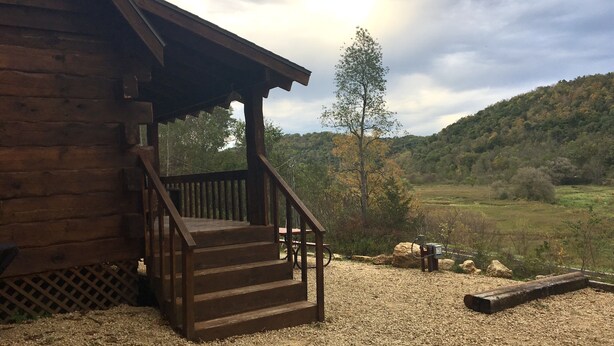 Eine Holzhütte mit Veranda und Treppe zu einem Picknicktisch.